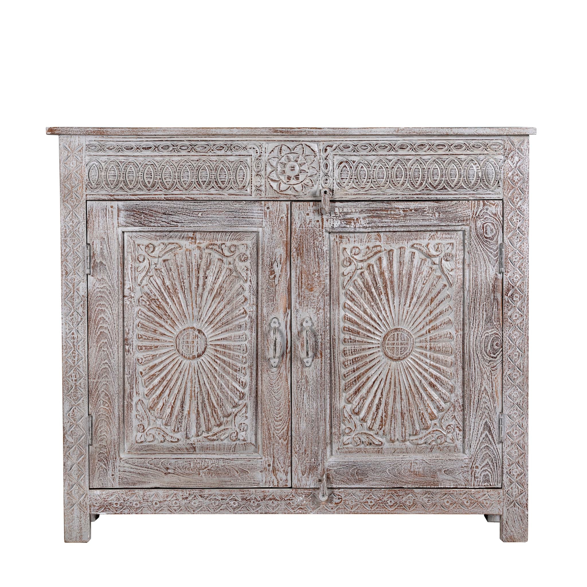 Close up image of a grey-washed reclaimed wood cabinet with hand-carved floral and sunburst detailing, a vintage furniture piece perfect for rustic or bohemian interiors.