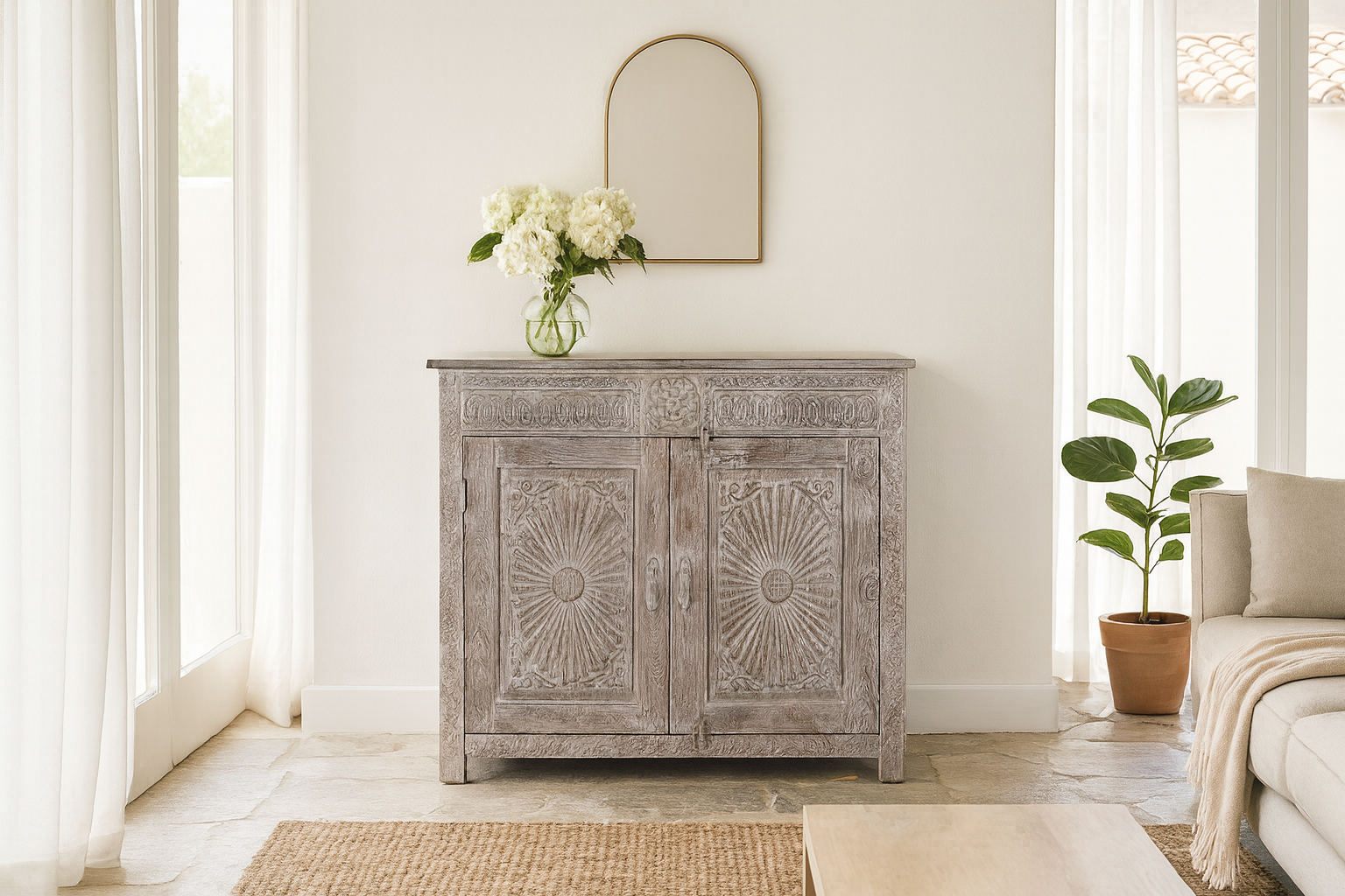 Lifestyle image of a grey-washed reclaimed wood cabinet with hand-carved floral and sunburst detailing, a vintage furniture piece perfect for rustic or bohemian interiors.