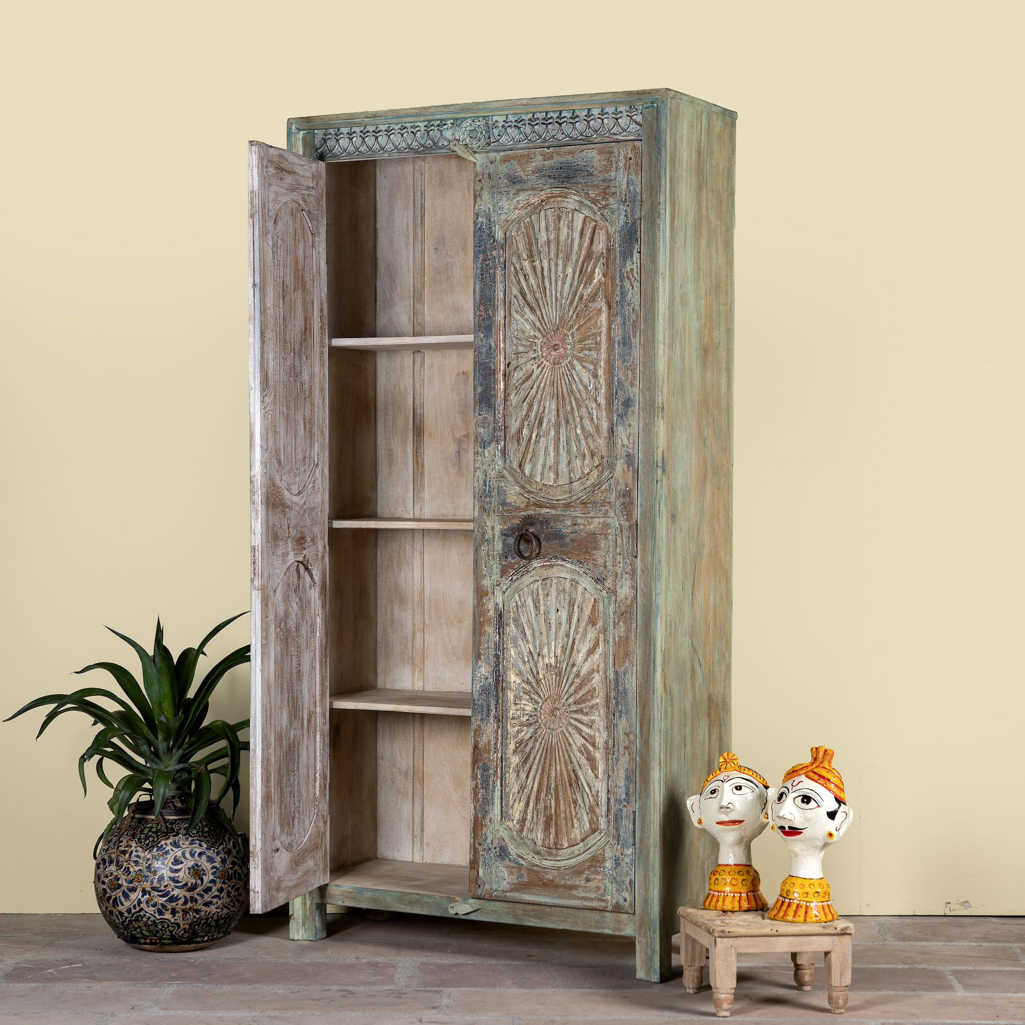 Side angle image with open doors of a hand-carved reclaimed wood wardrobe with vintage sunburst design – a sustainable furniture piece perfect for Indian home decor and rustic interiors.