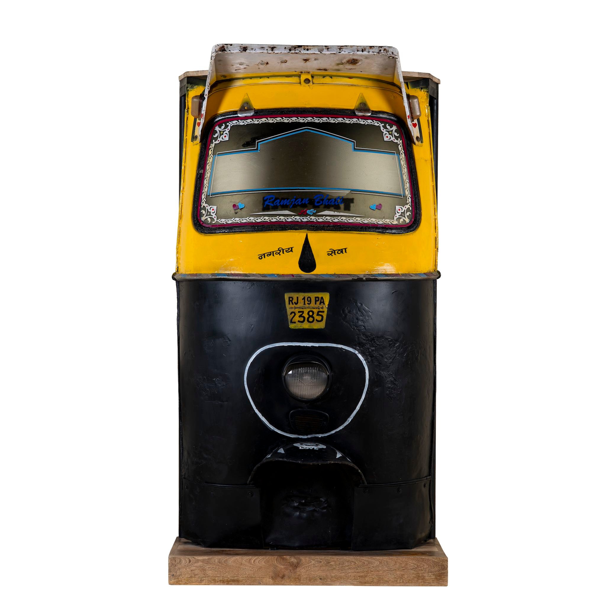 Unique bar table crafted from the front part of an old Indian rickshaw, featuring vibrant yellow and black paint with original details and functioning light.