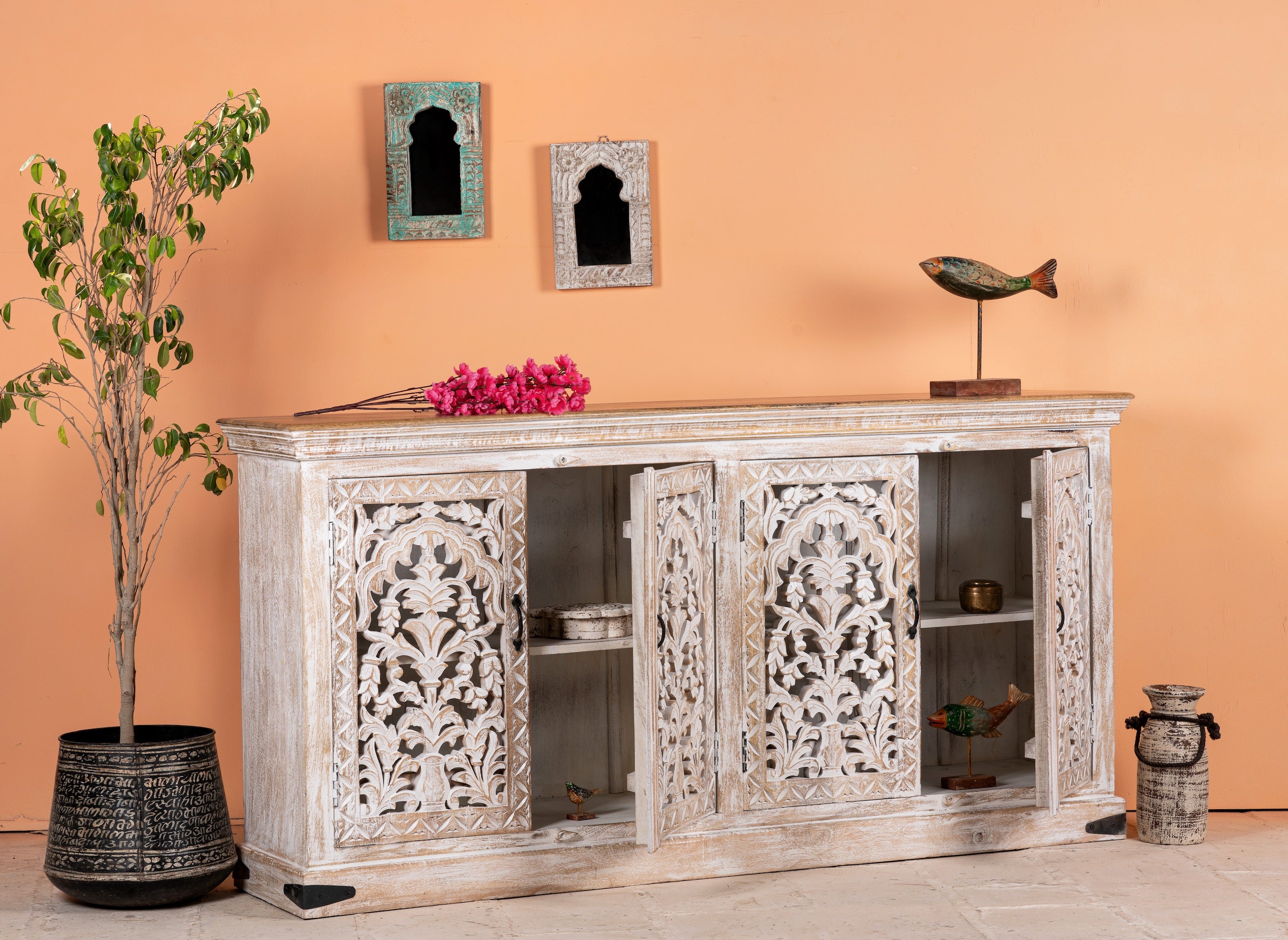Open door image of a hand-carved whitewashed mango wood sideboard with intricate floral detailing, perfect for a boho chic living room or vintage-inspired interior.