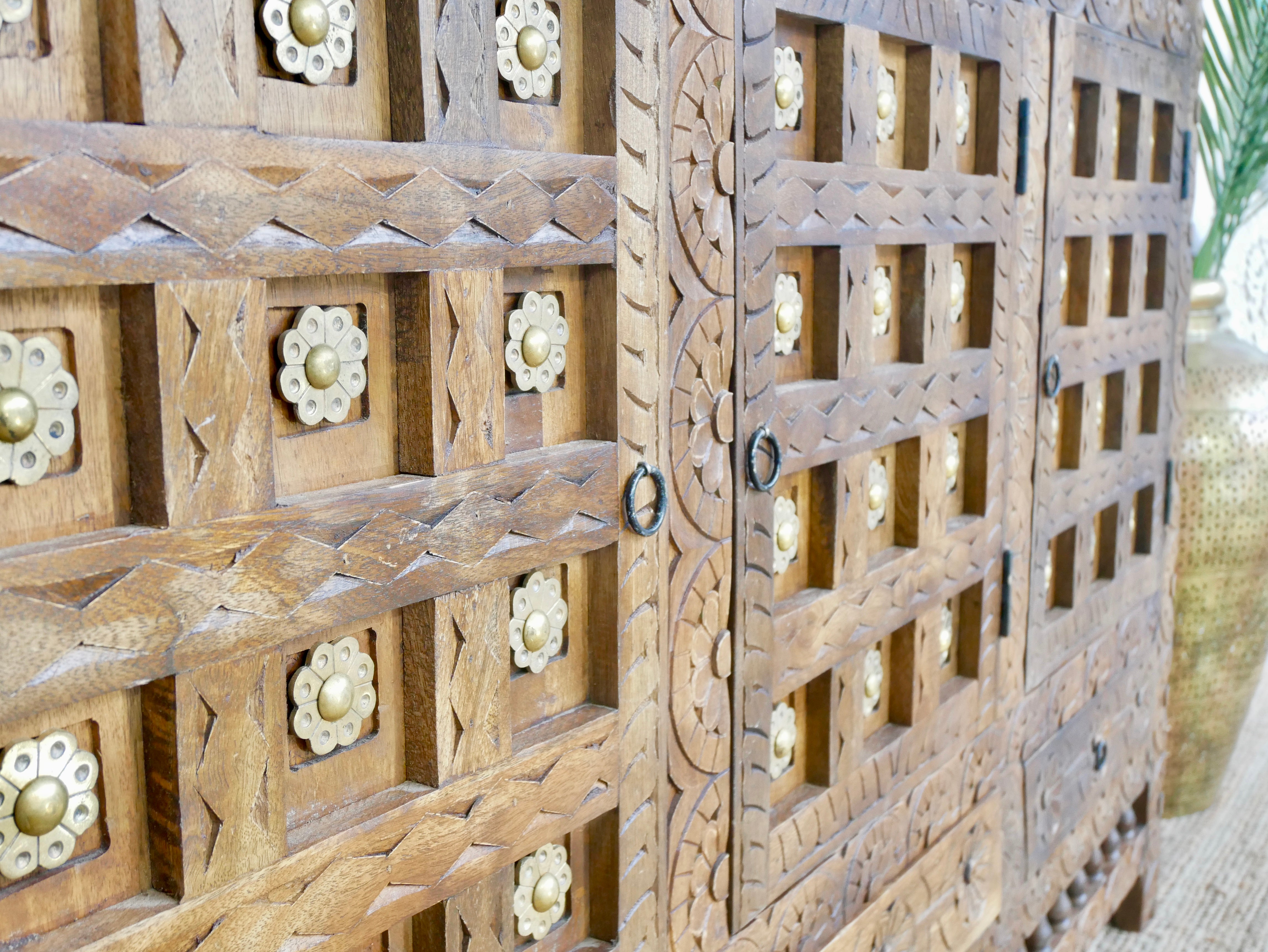 Close up image of a handcrafted traditional sideboard made from mango wood with Indian carvings and brass inlay; Indian furniture, 150 × 100 × 40 cm.