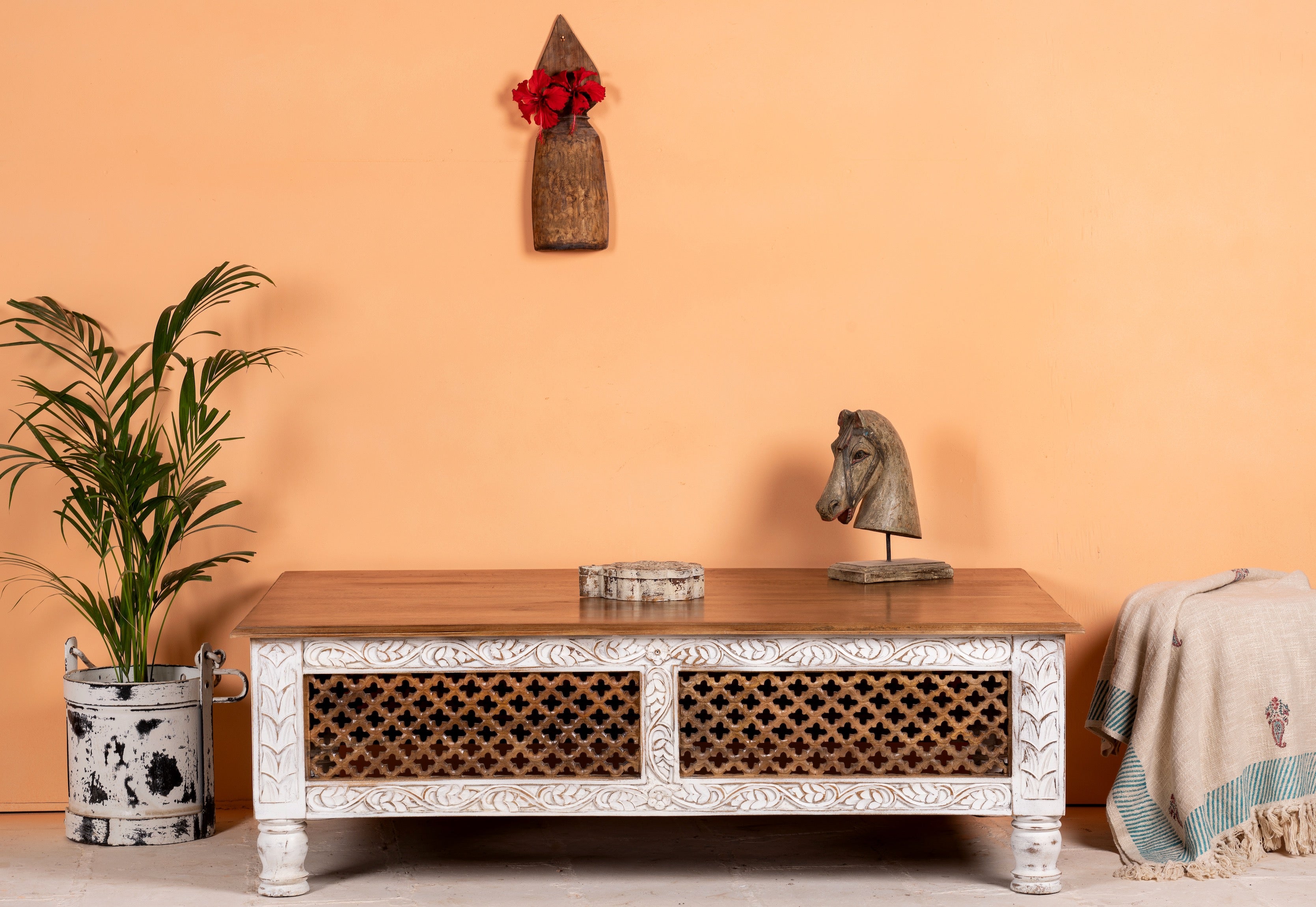 Hand carved mango wood coffee table with floral frame detailing; rustic natural finish, 140 × 90 × 46 cm.