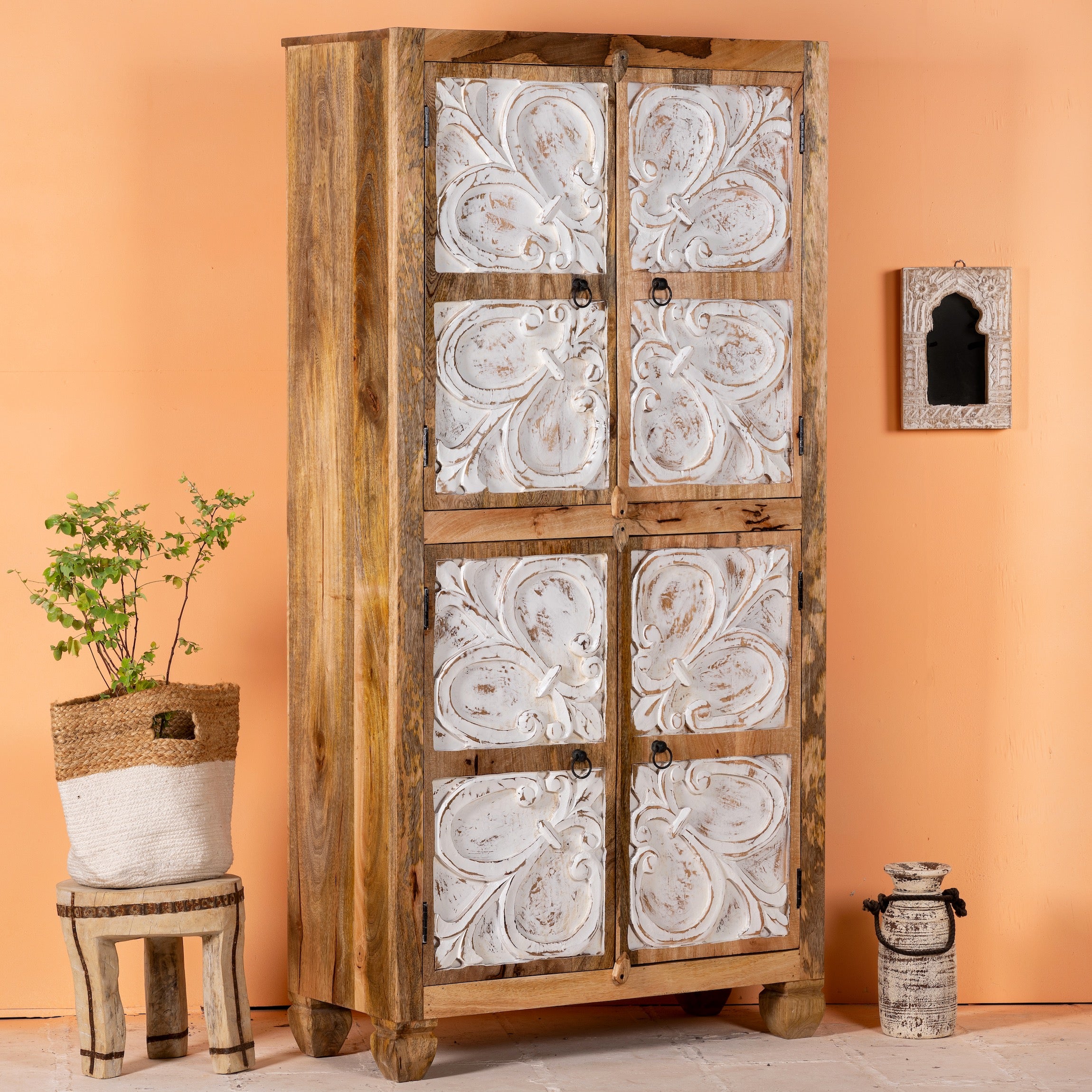 Side angle image of a hand-carved mango wood wardrobe with floral motifs and whitewashed finish; wooden wardrobe ideal for bedroom furniture, 90 × 180 × 40 cm.
