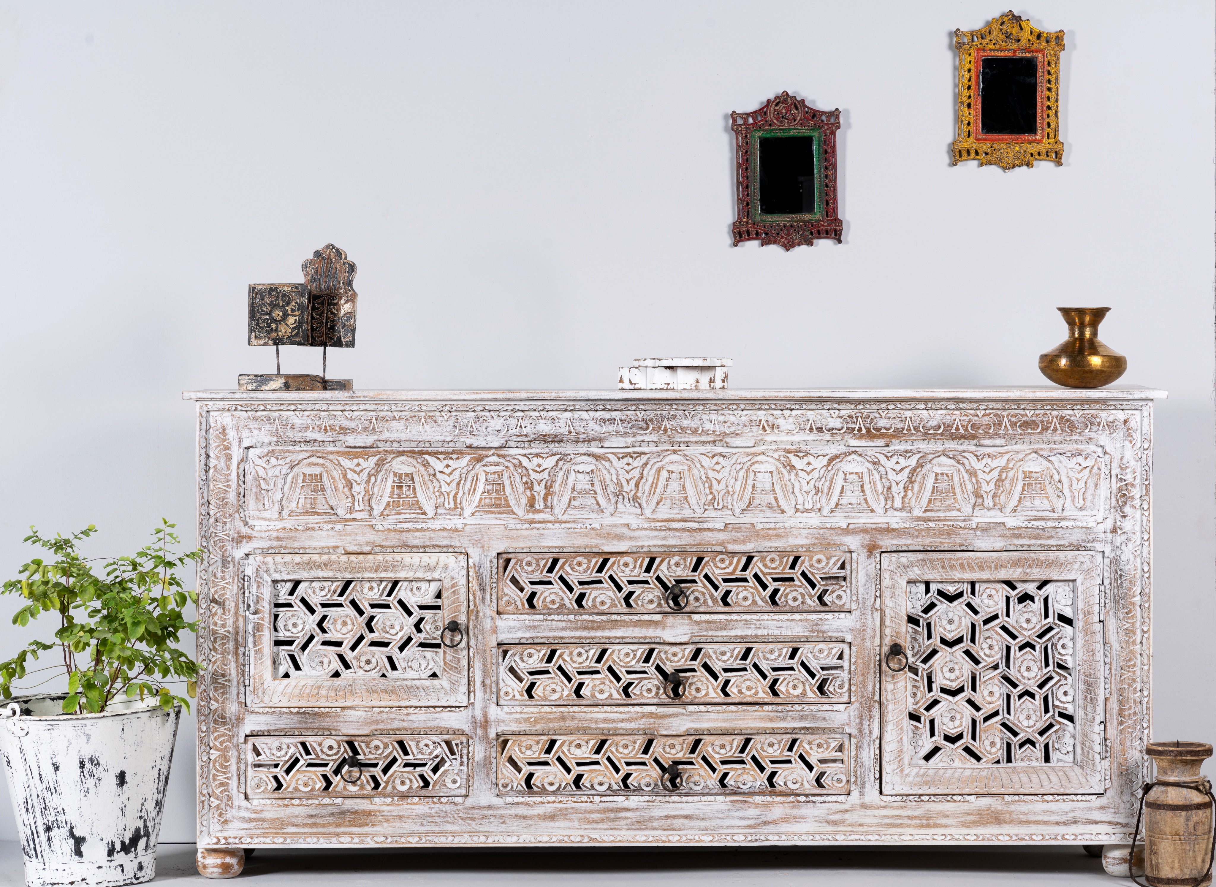 Lifestyle image of a hand-carved wooden sideboard made from solid mango wood with drawers and compartments; unique furniture piece in Mediterranean style, 180 × 100 × 40 cm.