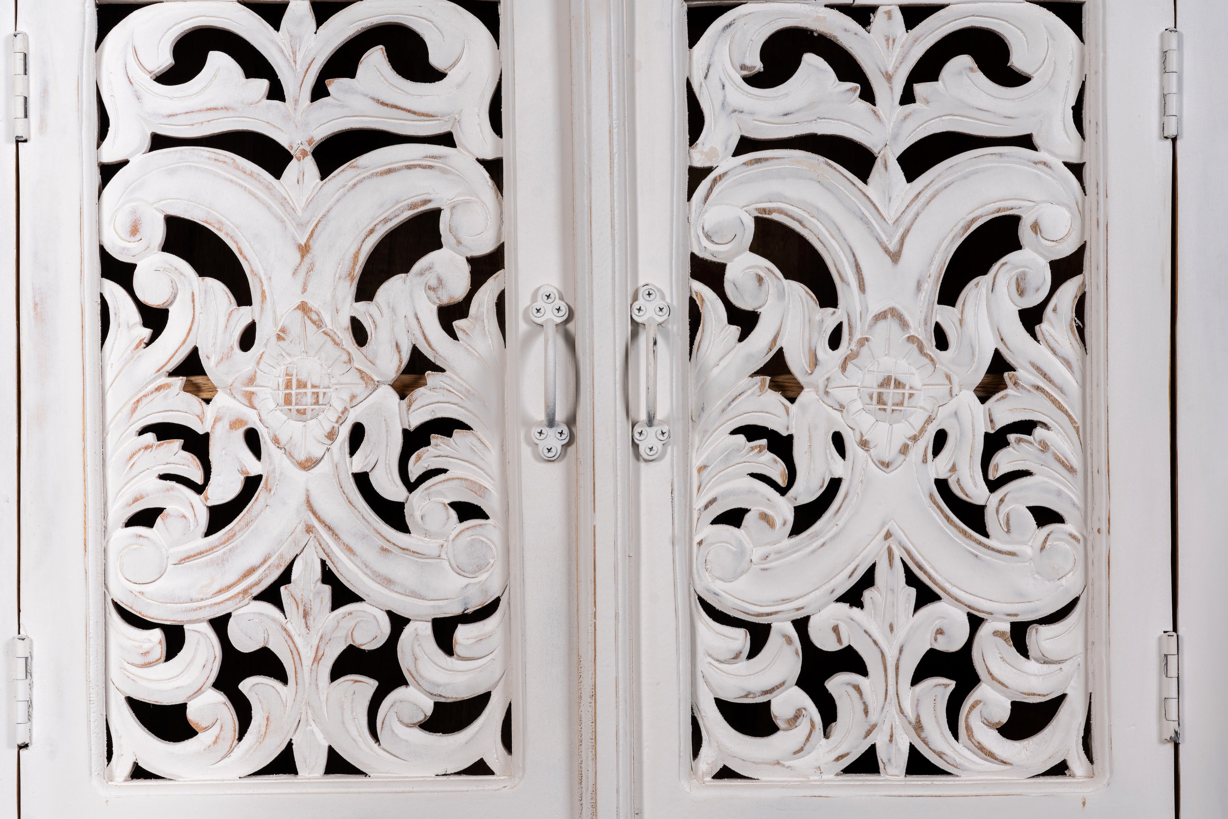 Close up image of a hand-carved mango wood shelving unit with white washed finish and storage compartments – white washed wooden furniture ideal for vintage home accessories and Indian decor style.