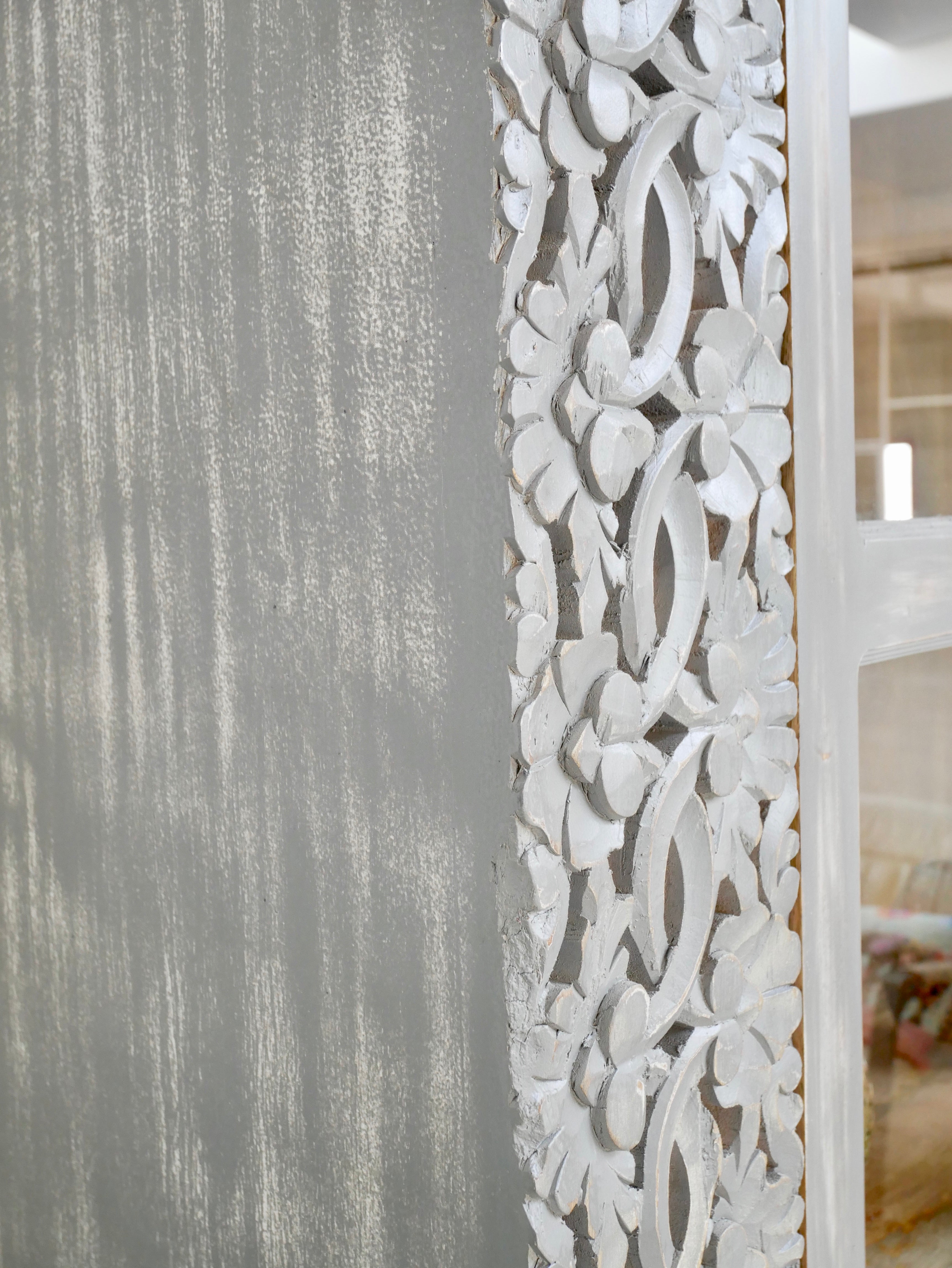 Close up image of a handcrafted mango wood cabinet with glass-panelled doors and internal storage – carved wood furniture made from sustainable mango wood with unique natural grain.