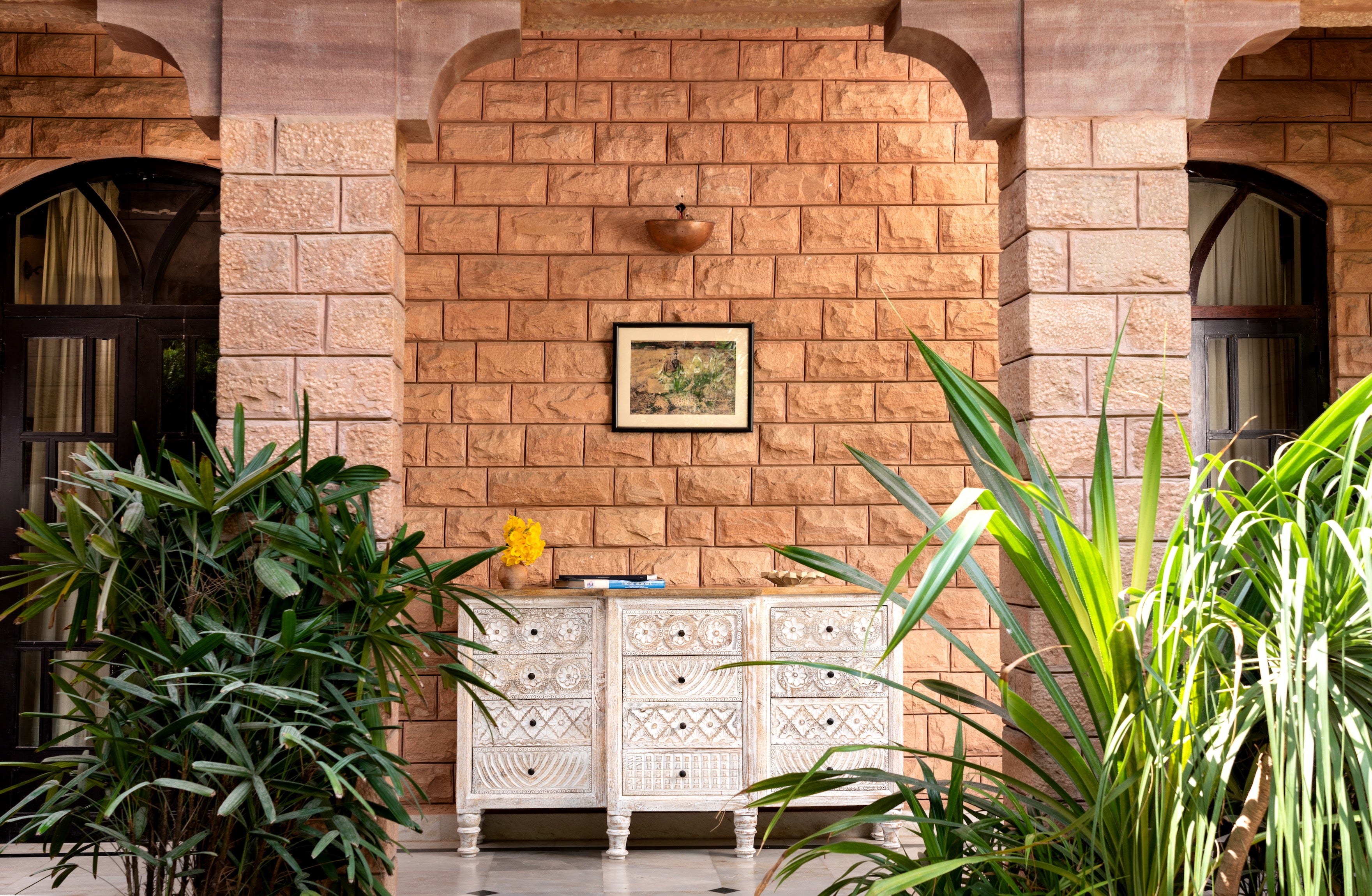 Lifestyle image of a hand-carved mango wood sideboard with lotus-inspired drawer motifs and whitewashed finish; a wood carved sideboard and unique furniture piece, 160 × 92 × 45 cm.