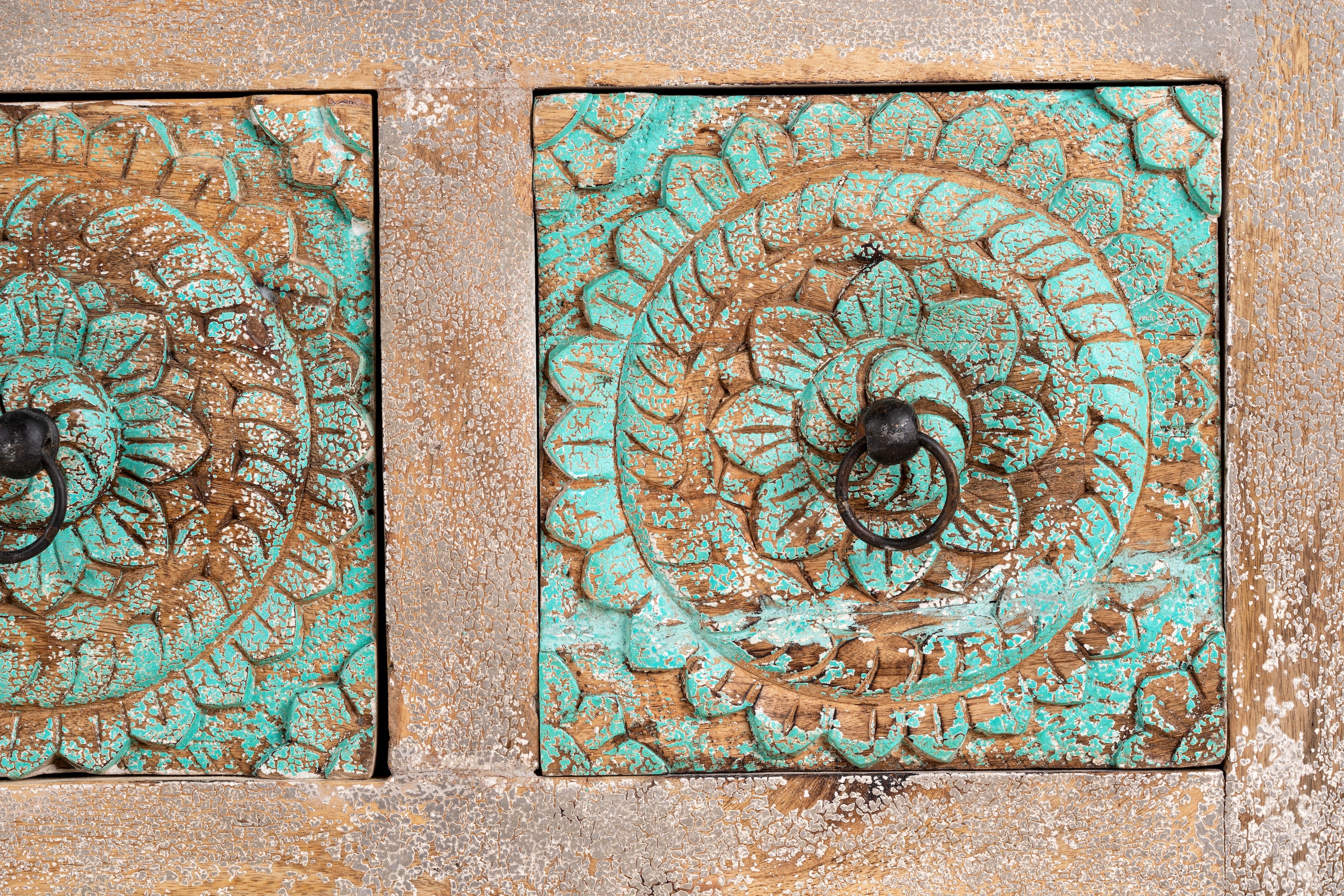 Close up image of a hand-carved mango wood vintage chest of drawers with greenwashed floral fronts and antique white finish; perfect for bedroom furniture, 90 × 100 × 40 cm.