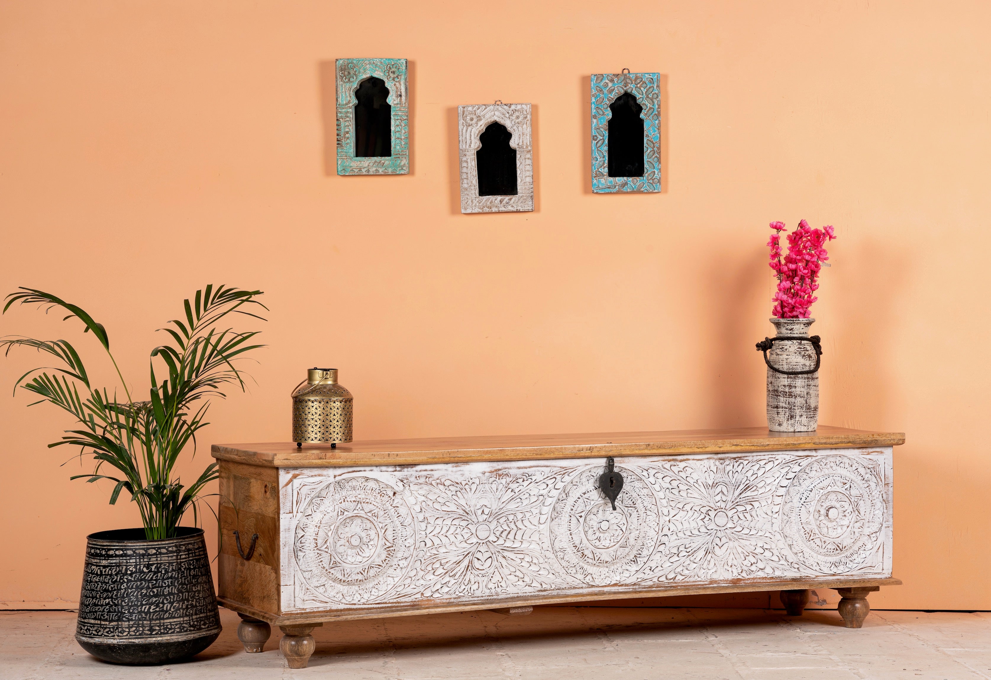 Side angle image of a long mango wood vintage display box and wood chest box with hand‑carved circular motifs, iron fittings and whitewashed finish; 180 × 55 × 46 cm.