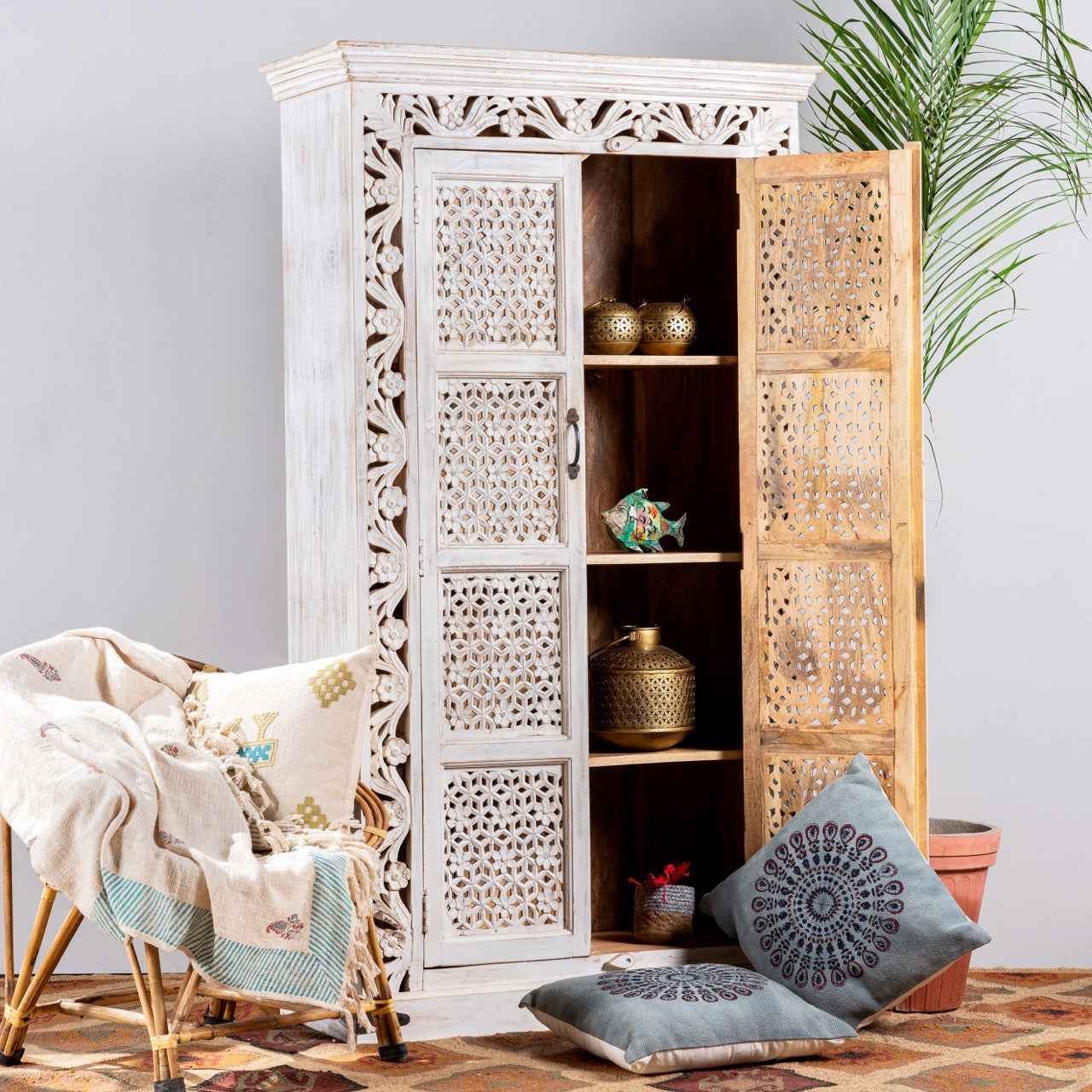 Side angle image with open door of a hand-carved mango wood cabinet with floral and geometric patterns in white-wash finish – carved wooden furniture and artisanal furniture with Mediterranean charm.