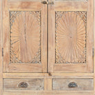 Close up image of a reclaimed teak wood showcase Aasta with Mediterranean design, featuring hand-carved doors, glass panels, and drawers. A unique piece of refurbished Indian furniture offering elegant display and practical storage.