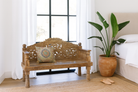 Life style image of a hand carved mango wood bench, featuring intricate floral detailing and turned legs, representing traditional Indian craftsmanship and authentic hand carved wooden furniture design.