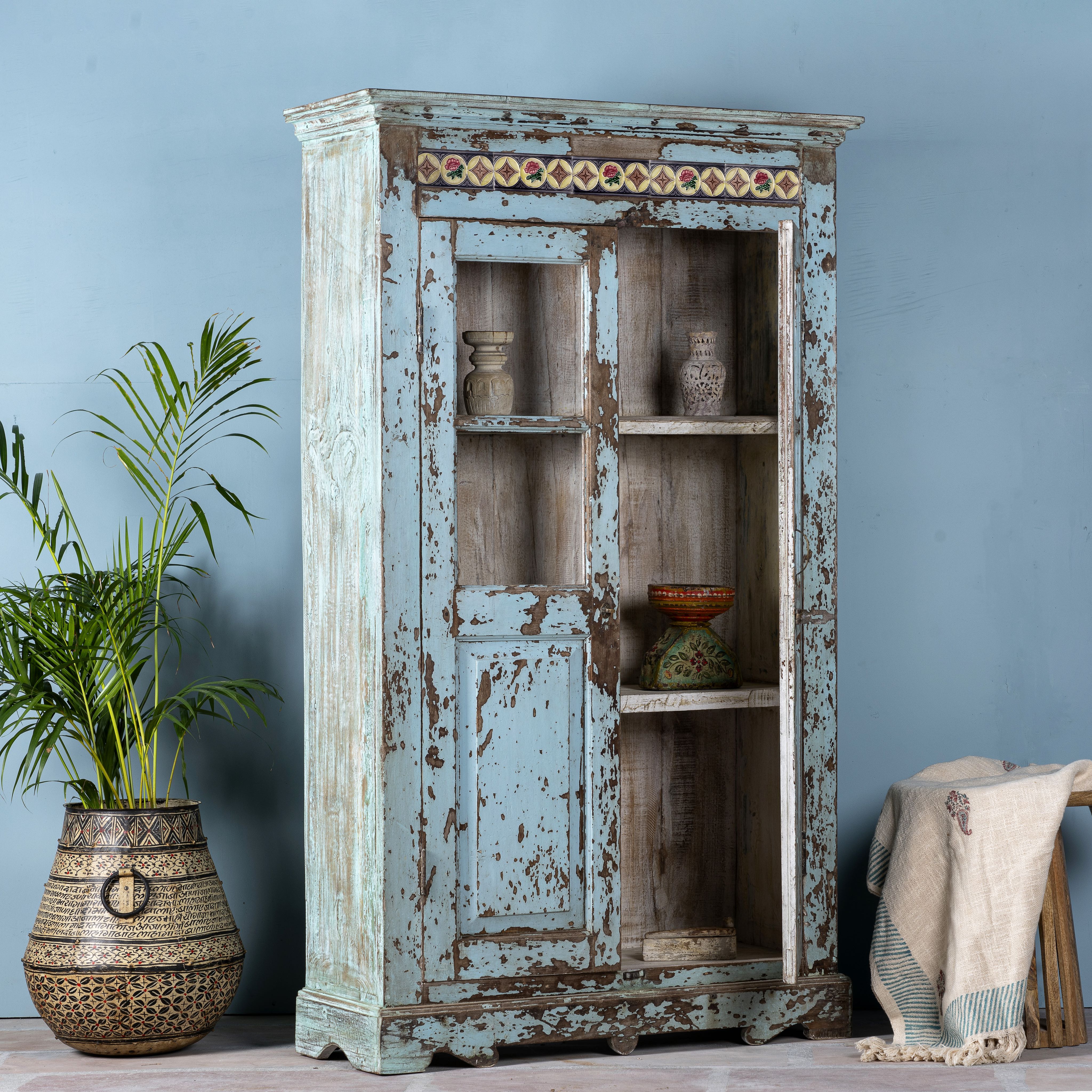 Side angle image with open door of a reclaimed teak wood display cabinet with light blue shabby chic finish and ceramic inlays – sustainable teak wood showcase with glass doors.
