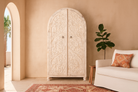 Lifestyle inspiration of an arched wooden wardrobe made of mango wood with hand-carved floral details; hand carved wooden furniture in Ibiza style, 190 × 100 × 40 cm.