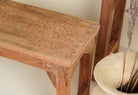 Close up image of the vintage school bench set Adil from India, crafted from old teak wood, featuring a simple, sturdy design with a long bench and matching table in a natural, weathered finish, styled in a neutral-toned interior with rustic decor accents.

