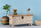 Side angle image of a hand-carved mango wood chest box with floral whitewashed detailing and iron handles – vintage home accessory and unique furniture with rustic charm.