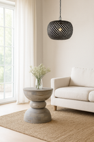 Lifestyle imagination of a vintage style mango wood coffee table with rounded form and grey-washed finish; compact rustic accent table, 40 cm diameter, 46 cm height.