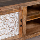 Wooden cabinet with intricate carvings and a decorative panel.