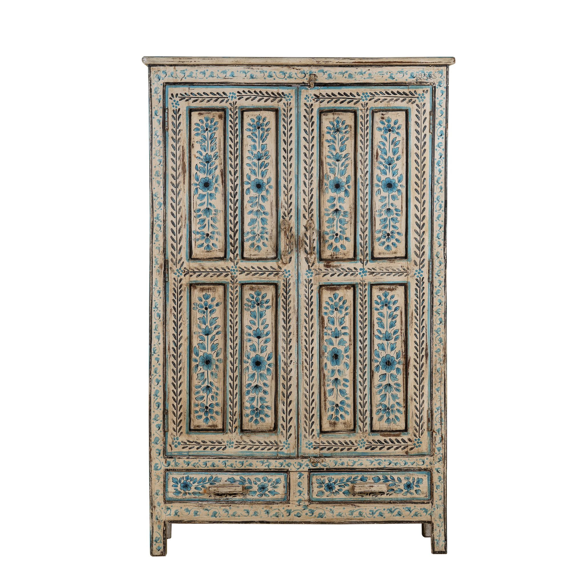 White background image of a tall cabinet made from reclaimed wood, featuring hand-painted floral motifs in soft blue tones on panelled doors and drawers, with a distressed finish that adds vintage charm and highlights its artisanal craftsmanship.
