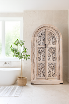 Lifestyle imagination of a arched wooden wardrobe with Tree of Life carving, mango wood, sandblasted finish; unique storage cabinet 100 × 42 × 190 cm.