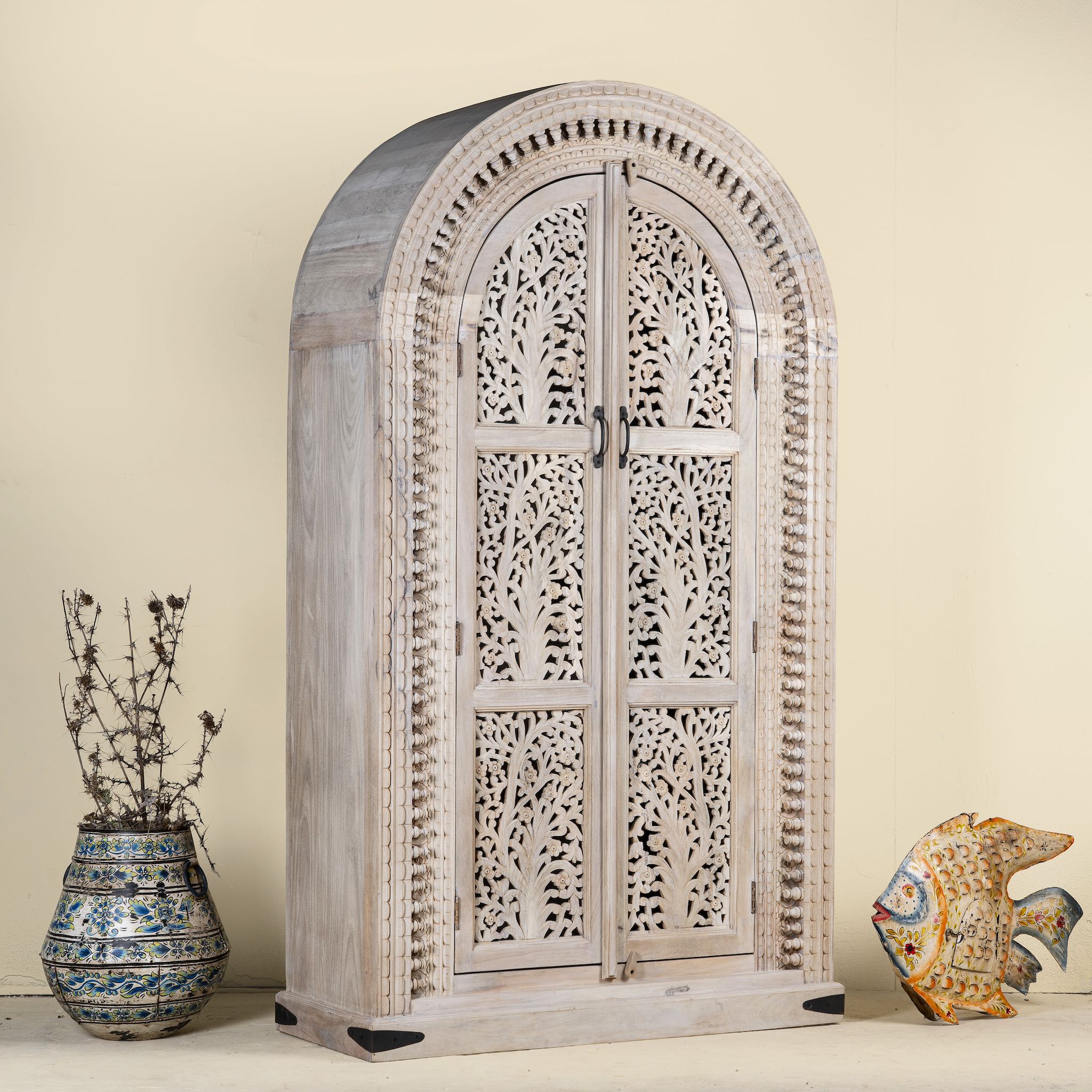 Decorative wooden cabinet with intricate carvings on a beige background