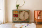 Lifestyle image of a hand painted sideboard Ashara made of mango wood with rattan inserts; Ibiza-inspired boho chic furniture, 120 × 40 × 92 cm.