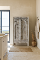 Lifestyle image of a handcrafted cabinet with reclaimed Indian window frame doors, white-washed finish, and iron accents – vintage home decor with teak furniture appeal.