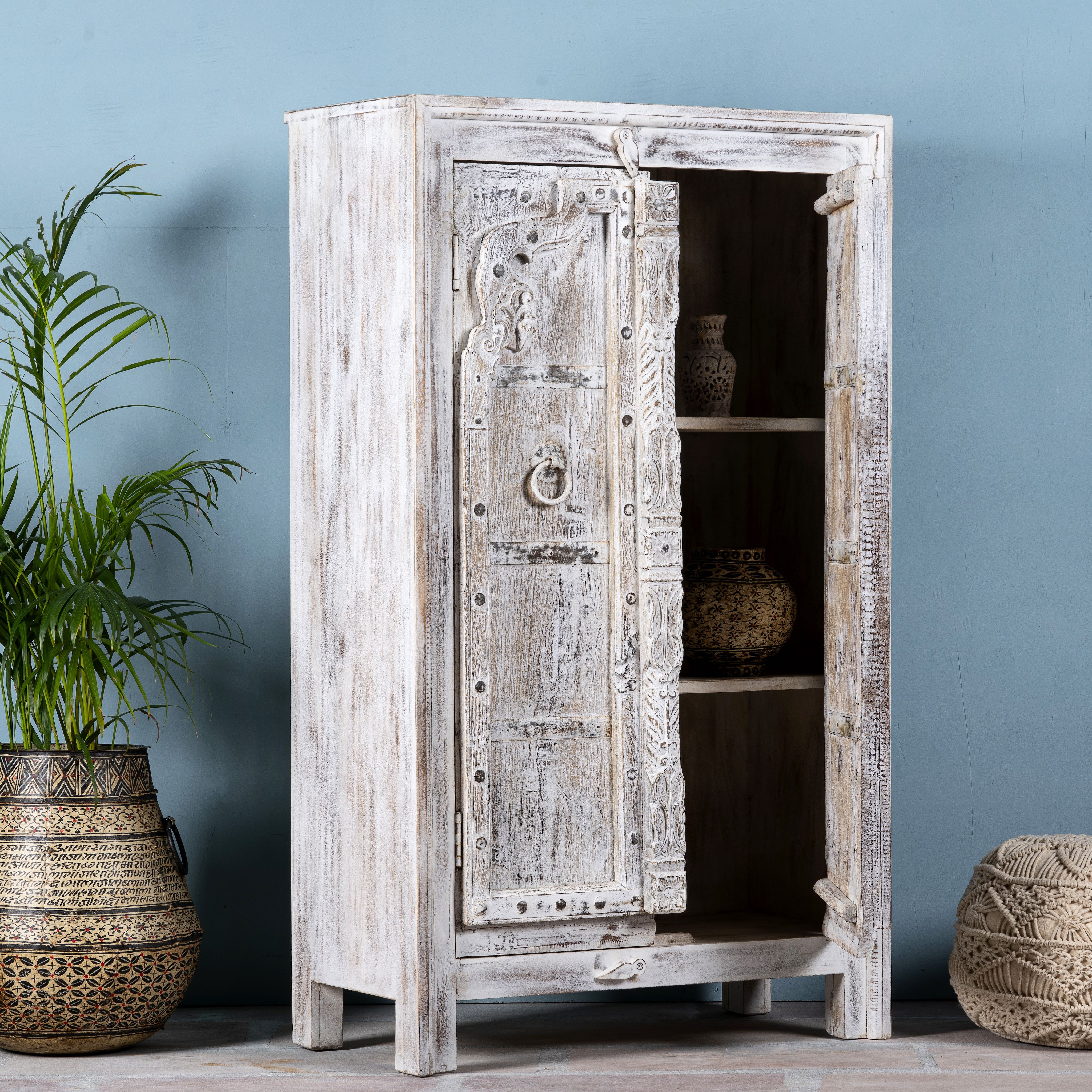 Side angle image with open doors of a handcrafted cabinet with reclaimed Indian window frame doors, white-washed finish, and iron accents – vintage home decor with teak furniture appeal.