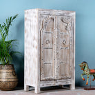 Side angle image of a handcrafted cabinet with reclaimed Indian window frame doors, white-washed finish, and iron accents – vintage home decor with teak furniture appeal.