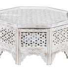 White background image of a octogonal mango wood coffee table with floral carvings and white wash finish; hand-carved and rustic, 90 × 90 × 46 cm.