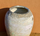Close up image of an antique clay vase with aged texture – a handcrafted Bali style clay vase ideal for Indian home decoration and earthy boho interiors.
