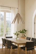 Lifestyle image of a vintage pendant lamp crafted from white-washed mango wood with a floral design and brass-plated hanger – a refined mango wood lighting piece for bedrooms, living rooms, or dining areas.