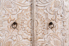 Close up image of a hand-carved mango wood Mediterranean lowboard with floral engravings and whitewashed finish – carved wooden furniture combining traditional Indian craftsmanship with rustic elegance.