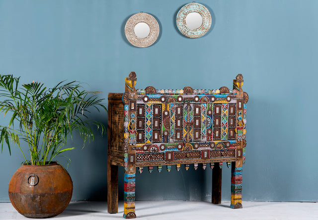 Side angle image of a restored antique Indian Damchia chest crafted from teak wood with original paint, metal fittings, and mirror inlays—an authentic piece of unique Indian furniture for traditional or bohemian interiors.