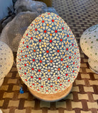 Close up of the lighted mosaic corpus of a Mosaic pendant lamp Bhuv with round ceiling panel and 7 hanging mosaic stone lights – handcrafted lighting design, 60 cm panel with 30x20 cm teardrop light bodies.