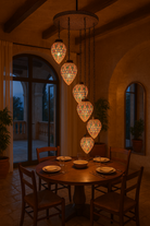 Livestyle image of a mosaic pendant lamp Bhuv with round ceiling panel and 7 hanging mosaic stone lights – handcrafted lighting design, 60 cm panel with 30x20 cm teardrop light bodies.
