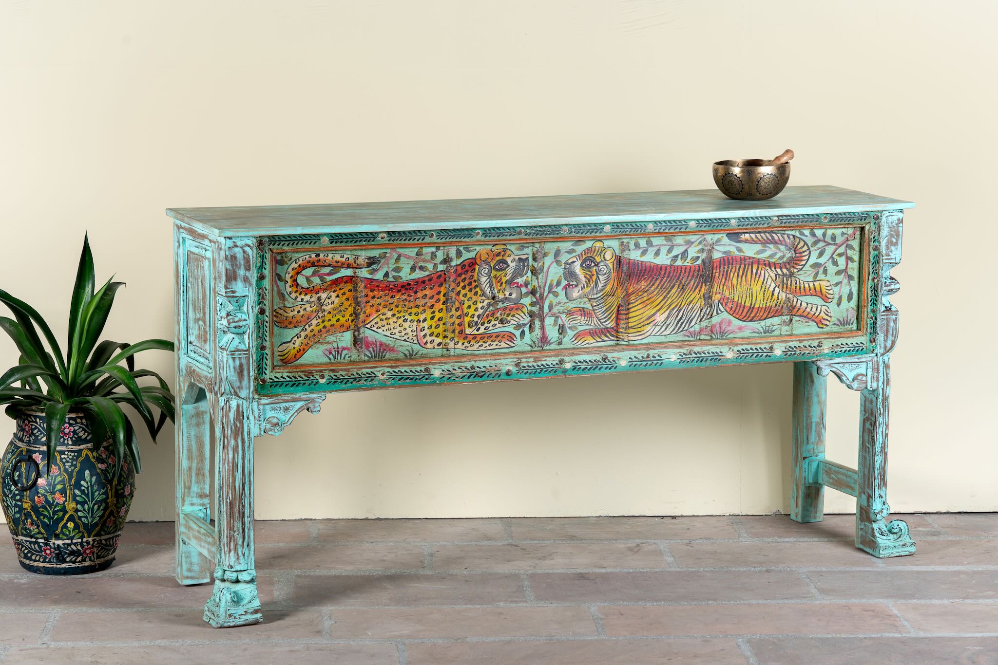 Side angle image of a hand-painted reclaimed wood console table Bunsee with tiger and leopard motifs in turquoise vintage finish. A unique piece of furniture for bohemian interiors and artistic spaces.