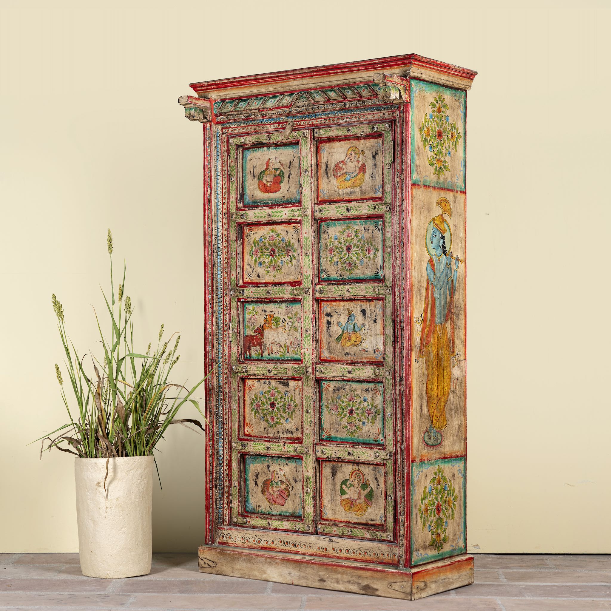 Side angle image of a antique hand painted wardrobe made from reclaimed teak wood with Indian motifs; unique furniture and teak wood furniture, 113 × 50 × 190 cm.