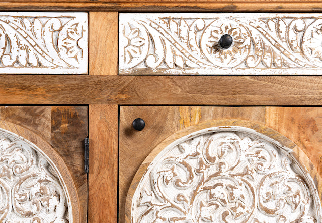 Close up image of a hand carved wooden sideboard made from mango wood with floral carvings and curved base, mango wood furniture with storage, 150 × 40 × 95 cm.