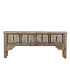 White background image of a hand-painted console table made from reclaimed teak wood, featuring intricate floral motifs in blue tones across the front panels, framed by carved detailing and a distressed finish that highlights its artisanal and vintage character.
