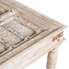 Close up image of a qhite washed old door coffee table made of antique teak wood; handcrafted Indian coffee table, 183 × 100 × 45 cm.