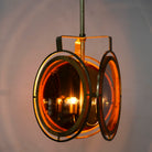 Image showing a lighted artsy pendant lamp with 3-circle mango wood and brass-plated design, tinted glass inserts – vintage lighting piece for dining rooms, kitchens, or stylish living areas.