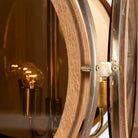 Close up image of a artsy pendant lamp with 3-circle mango wood and brass-plated design, tinted glass inserts – vintage lighting piece for dining rooms, kitchens, or stylish living areas.