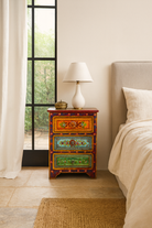 Lifestyle scene with a hand-painted vintage night stands with floral motifs – unique Indian furniture made from recycled wood for artistic and bohemian interiors.