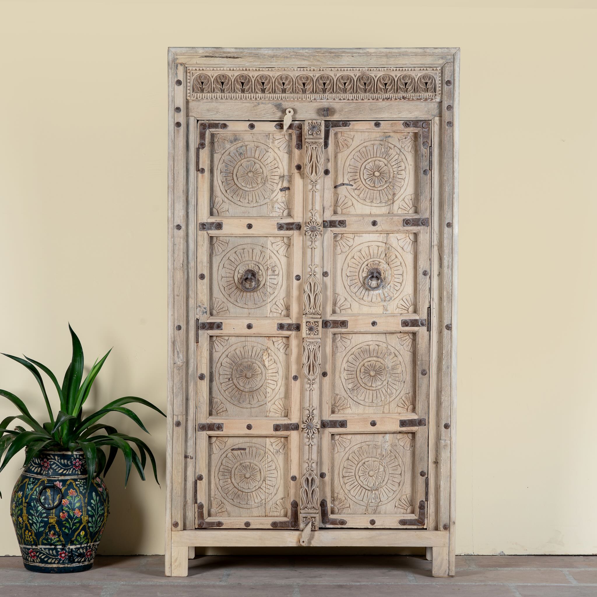 Reclaimed teak wood cabinet Elayna featuring an antique Indian door with carved motifs and iron accents. A unique piece of old door furniture in Mediterranean style, offering practical storage and historic charm.