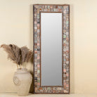 Front view image of a rectangular mirror framed with reclaimed wood, featuring a mosaic-style border of intricately carved and coloured wooden tiles, each with unique textures and patterns, creating a rustic and artistic statement piece.
