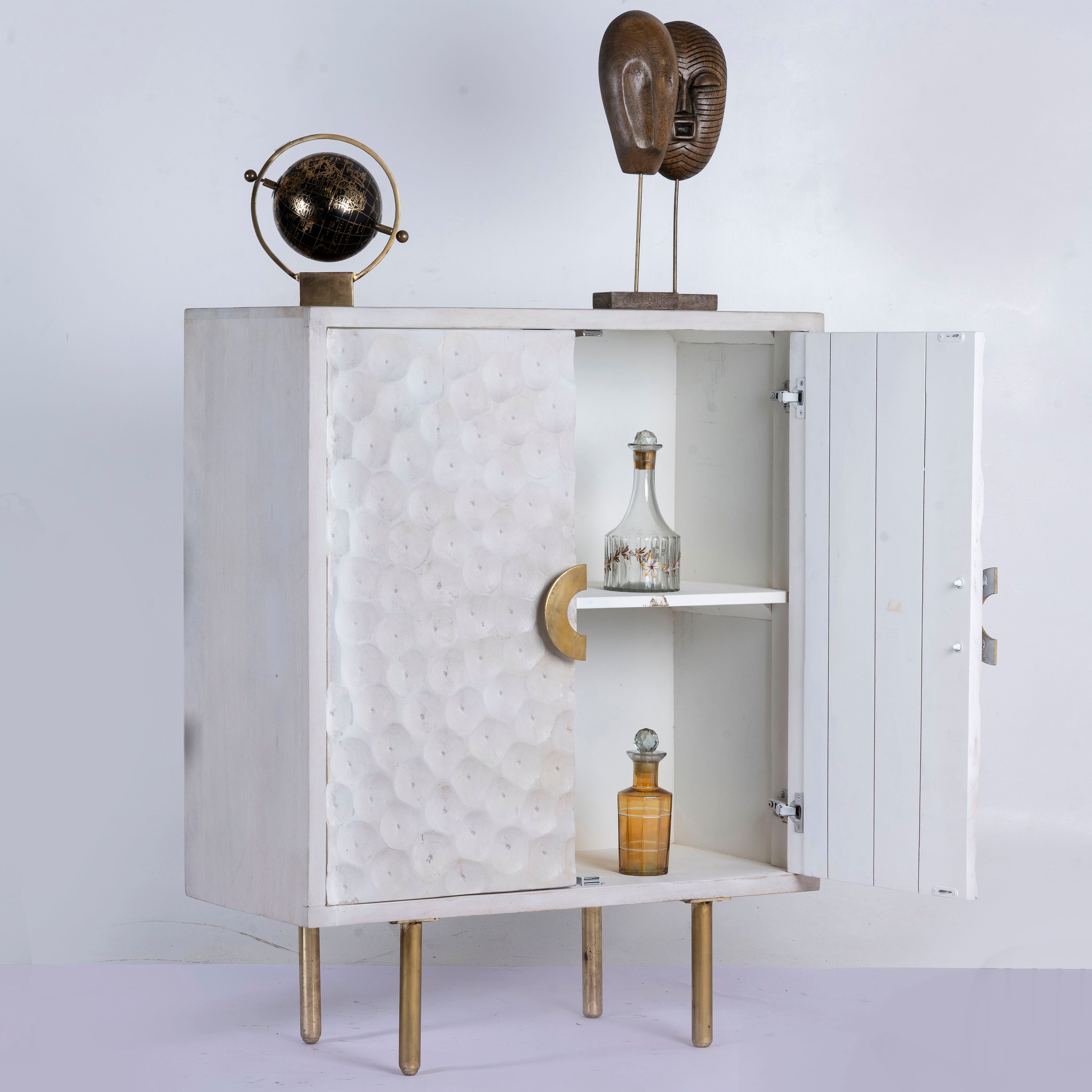 Open door image of a carved wood furniture cupboard in white mango wood with hammered pattern, brass iron base, 88 × 43 × 122 cm.