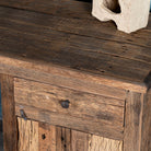 Close up view of a desk made of reclaimed wood in Wabi Sabi style decorated in a living room scene.