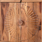 Close up picture of a carved acacia wood sideboard with four doors, two drawers, brass handles, and tapered legs; artisanal acacia wood furniture, 180 × 40 × 90 cm.